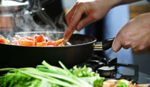 frying pan with vegetables cooking